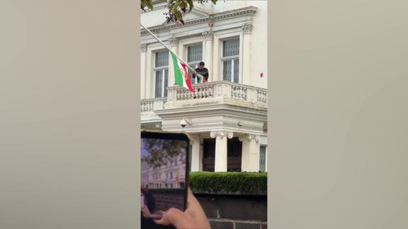 Protester scales Iranian Embassy in London, tears down regime flag, hoists pre-revolution symbol